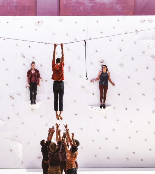 des acrobates montent sur une paroi