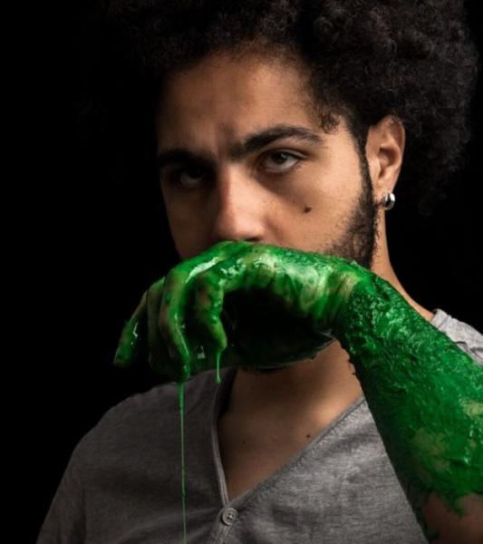 un homme, des mains peintes en vert